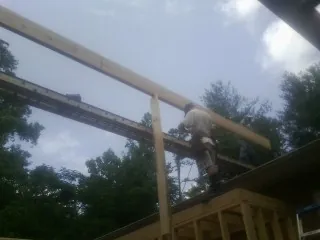 Carpenter setting a ridge beam over a new addition frame — Ice Dam Removal by Roofing Brothers in San Antonio