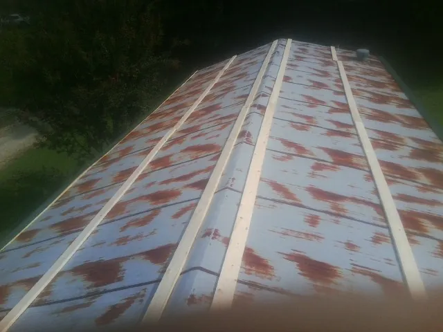 Rusted metal roof panels with new wood purlins before replacement — Storm Damage Roof Repair in San Antonio by Roofing Brothers