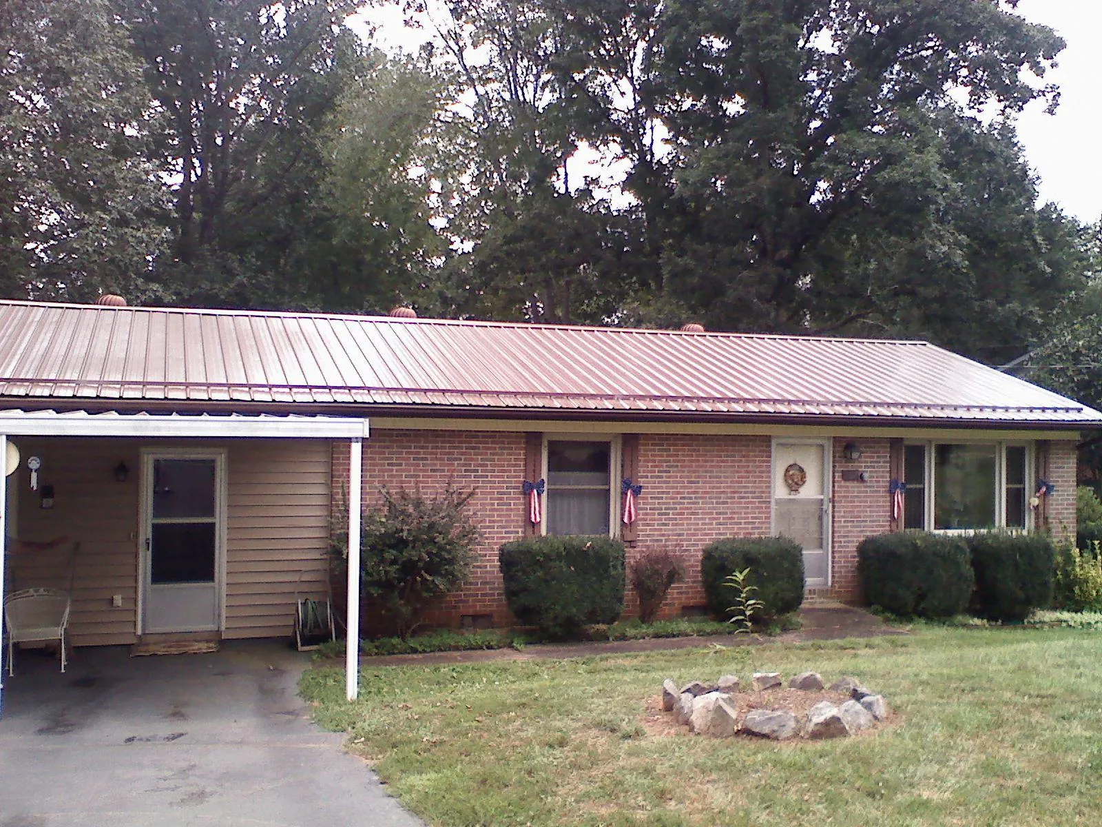 Bronze metal roof and carport on a brick ranch home — Roof Repair work by our crew in San Antonio
