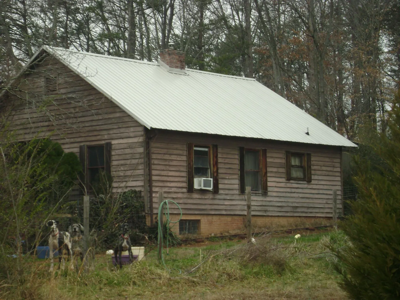 White metal roof on an old wood sided farmhouse, from a Asphalt Shingle Roof Repair job in San Antonio